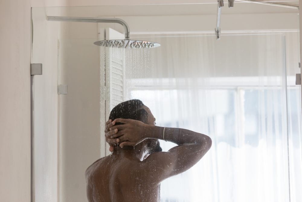 Man enjoying a hot shower, highlighting efficient water heating in Canberra