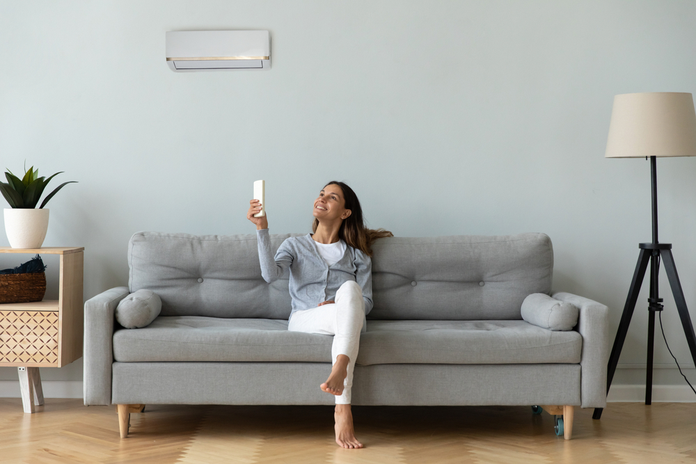 Woman using a remote to operate air conditioning in her Canberra home